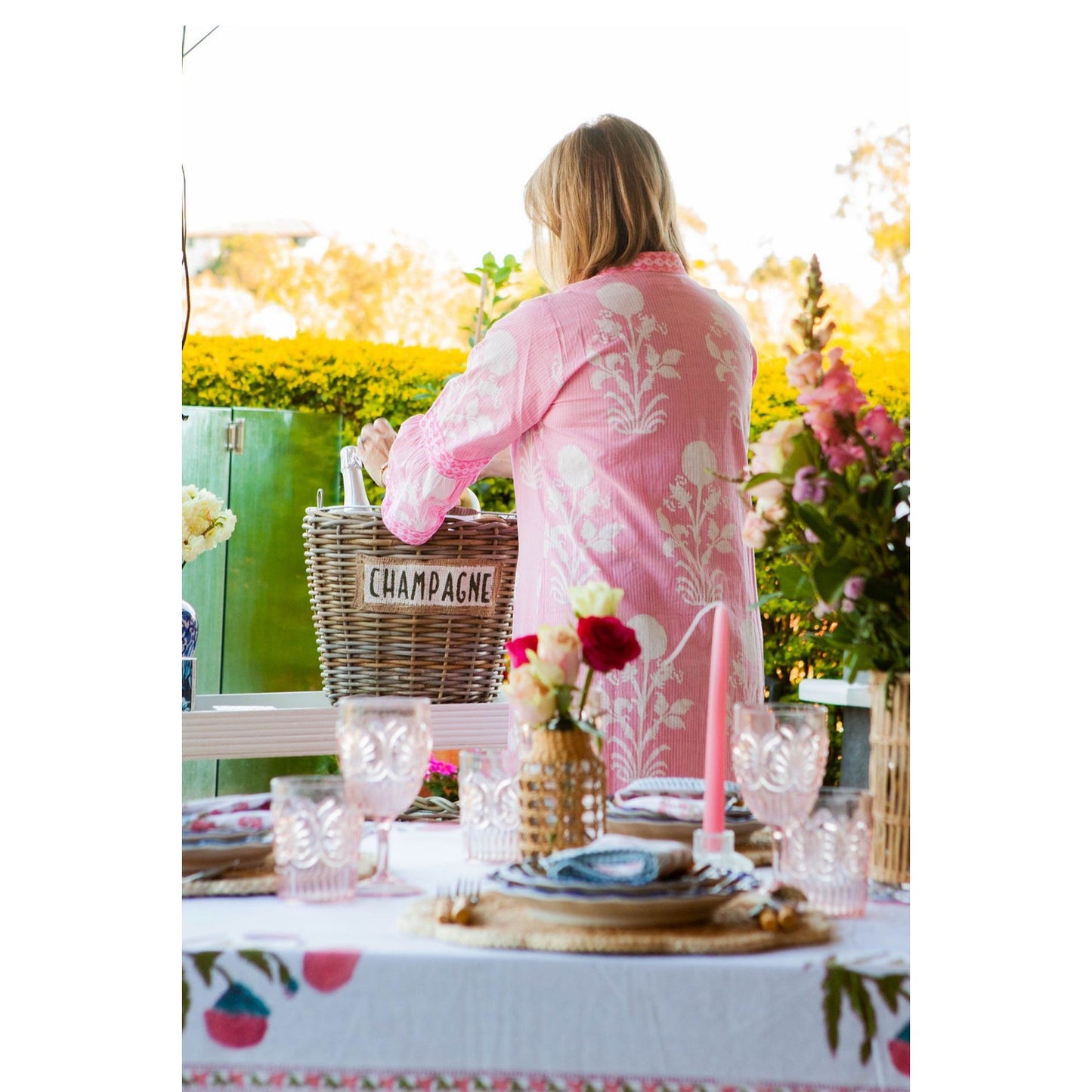 Woman in floral kaftan enjoying outdoor tea.