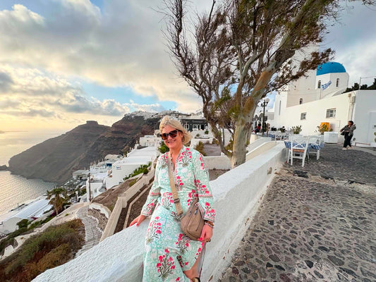 Carolyn wearing the Carolyn Kaftan in Santorini overlooking the Aegean Sea.